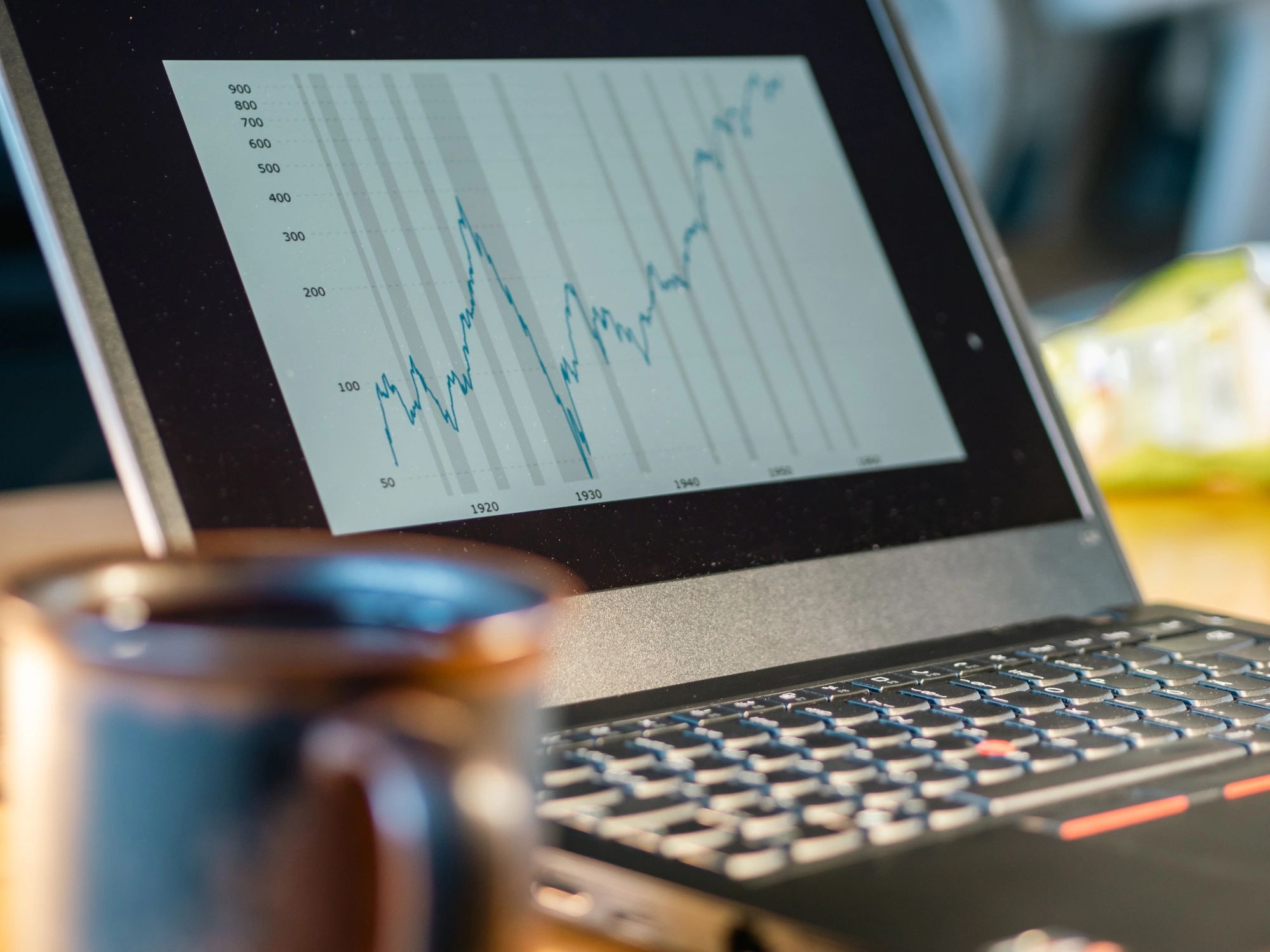 Laptop showing a rising financial chart representing stock market investing